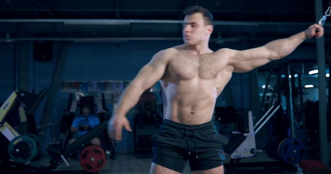 bodybuilder comes to the simulator and does the exercise in the gym