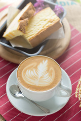 Cup of coffee with beautiful Latte art and butter cake, Selective focus
