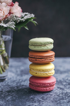 Stack of colorful macarons on grey background