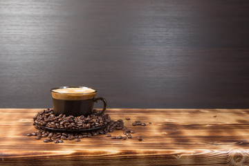 Coffee cup and saucer on a wooden table. Dark background.