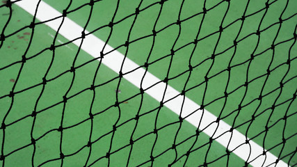 Fototapeta premium black tennis net on a green cement court