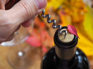 Corkscrew and bottle of red wine. Opening a bottle of wine. Close-up.
