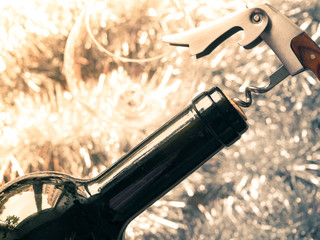 Corkscrew and bottle of red wine. Opening a bottle of wine. Close-up.
