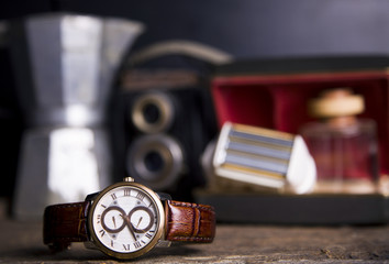 Closeup toned shot of male watches lying on table against photography retro set