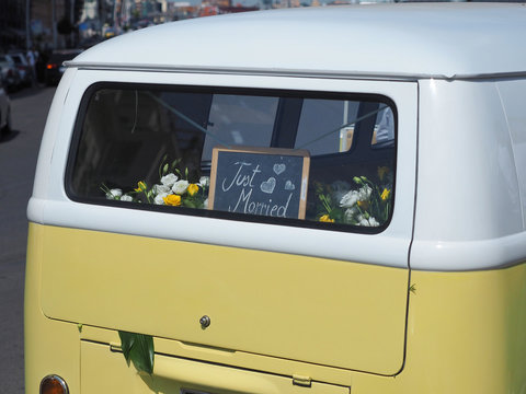 Yellow vintage multivan with the sign "Just Married" on rear window.