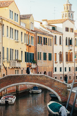 Fototapeta na wymiar Newlyweds kiss on the bridge somewhere in Venice