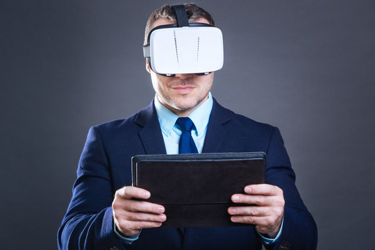 Delighted smart businessman standing with a tablet in his hands