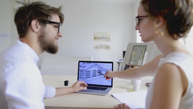 Two young architects with computer and tablet.