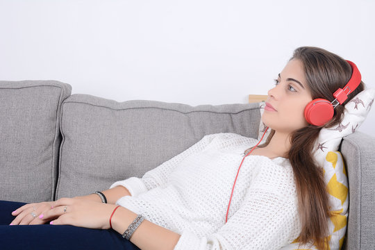 Woman listening music on couch.