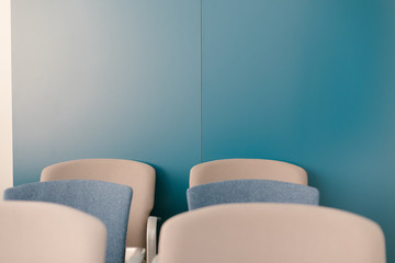 sillas azules y grises agrupadas en una sala de conferencia para una chala informal