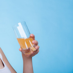 Woman holding glass of orange flavored drink