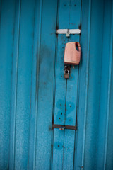 rusty old school blue door with a padlock