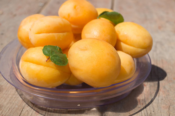Ripe orange apricots in the plastic plate close up