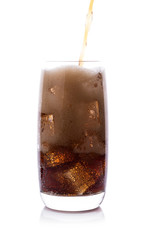 Bottle pouring Cola in drink glass with ice cubes