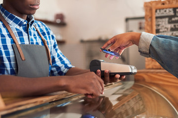 Cafe customer paying for her purchace with nfc technology