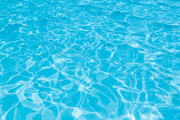 Blue and bright water surface and ripple wave with sun reflection in swimming pool