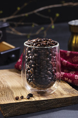 Fototapeta na wymiar Coffee beans in a glass on a piece of wood