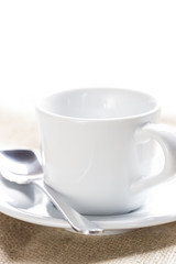 Obraz na płótnie Canvas White ceramic cup on a linen tablecloth