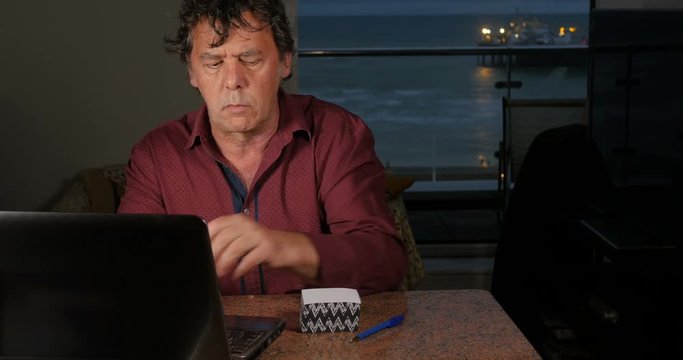 Adult caucasian man using personal computer and abacus for accounting