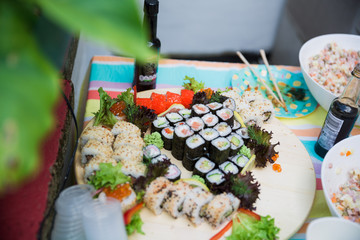 Photography of different sushi and salads on the table outdoors
