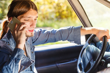 Man talking on phone while driving car.