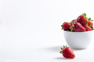 White ceramic bowl with strawberries, copyspace