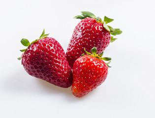 Three fresh strawberries on a white background