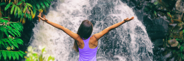 Freedom zen happy girl with open arms meditating yoga at nature waterfall banner panoramic. Hawaii...