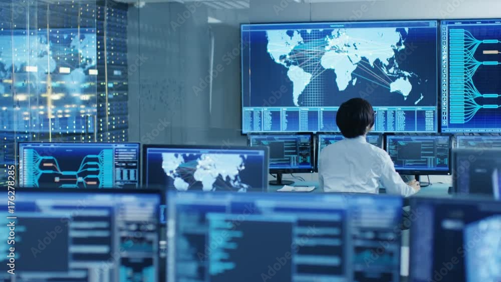 Leinwandbilder In the System Control Room Operator Sits at His Workstation with Multiple Displays Showing Graphics and Logistics Information. Shot on RED EPIC-W 8K Helium Cinema Camera.