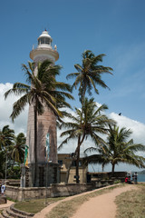 Fototapeta na wymiar light house and palm trees in Galle, Sri Lanka
