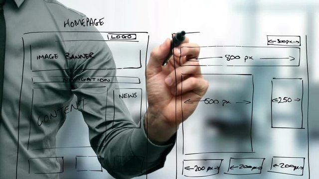 web designer drawing website wireframe in office