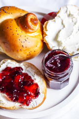 Cherry jam and fresh rolls on a white plate