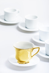 Empty white and gold cups on white