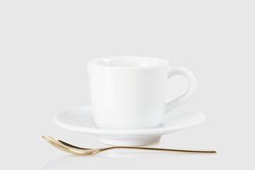 Espresso cup and golden spoon isolated on white