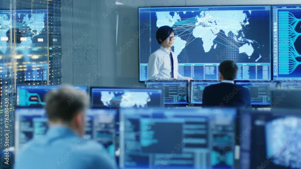 Aufkleber In the System Control Room Manager Holds a Briefing for His Staff Members. They're Work in Data Center and are Surrounded by Multiple Screens Showing Maps, Logistics Data. 