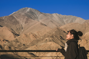 Fototapeta na wymiar A smiley beautiful Asian woman standing in front of Himalaya mountain view