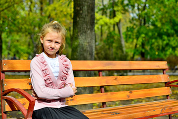Girl sitting in a bench in the park