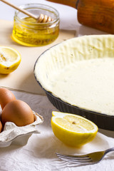 Lemon, eggs, honey, rolling pin and tart dough baking process