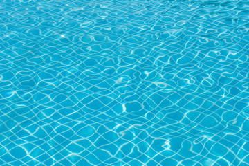 Blue and bright water surface with sunreflection in swimming pool