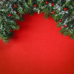 Creative layout made of Christmas tree branches with snow on red background. Flat lay. Nature Christmas concept