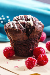 Chocolate muffin with raspberries on wooden board