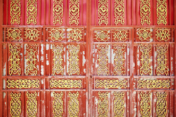 Old oriental iron door with peeling paint.