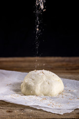 Sprinkling fresh dough with flour