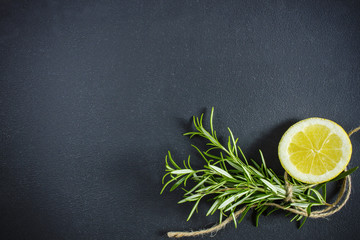 Rosemary and lemon on black with copyspace