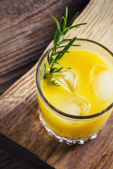 Orange and rosemary alcoholic drink on wooden board, view from top