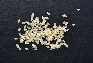 Rice flakes on black background. Top view.