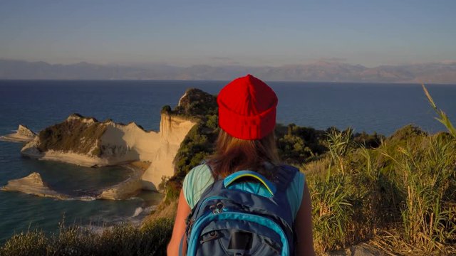 Woman with a backpack and map goes to the Cape Drastis at Corfu island in Greece
