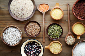 Cereals and legumes in bowls on wooden background.Top view
