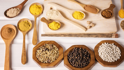 Different herbal and spice in wooden scoop on the table, Various ingredient in container for cooking flat lay on plank