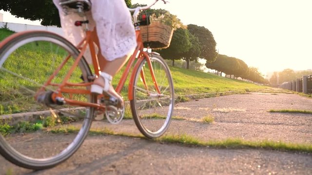 Young beautiful woman riding a bicycle at sunset. Slow motion